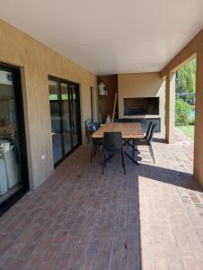 eine Terrasse mit einem Tisch und Stühlen auf einem Backsteinboden in der Unterkunft Quinta Ensenada in Bragado