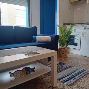 a living room with a blue couch and a table at María PLAYA MAR NG in Peniscola