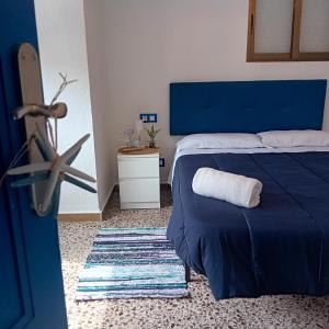 a bedroom with a blue bed with a towel on it at María PLAYA MAR NG in Peniscola