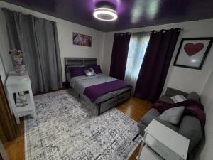 een slaapkamer met een bed en een bank bij Spacious Stay near Lambeau in Green Bay