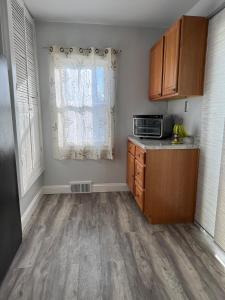 een keuken met houten kasten en een magnetron bij Spacious Stay near Lambeau in Green Bay +10 foto's