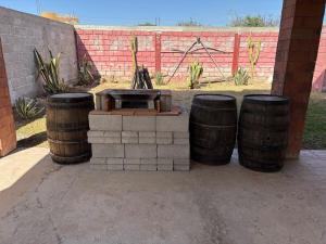 a fire pit with three barrels next to a fence at Casquito de Hacienda in Ezequiel Montes