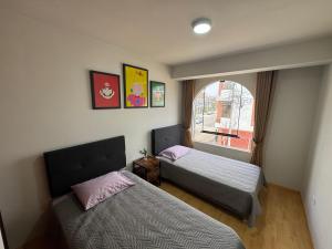 a bedroom with two beds and a window at Solena Apartamentos Tacna in Tacna