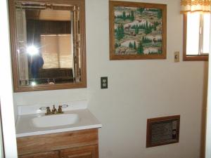 una persona tomando una foto de un lavabo del baño en Sierra Bonita Cabins and RV Park, en Guadalupita