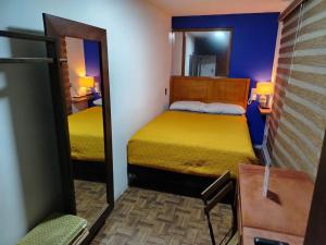 a small room with a bed and a mirror at Posada Familiar Lupita in Texcoco de Mora