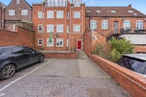 a car parked in a parking lot in front of a brick building at Spacious 1 Bedroom Apartment in Birmingham