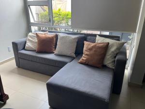a blue couch with pillows on it in a living room at Departamento zona EXPO GDL in Guadalajara