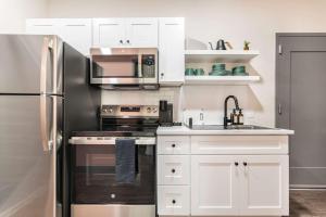a kitchen with white cabinets and a stainless steel refrigerator at Rock 'n' Soul Retreat Otis Meets Little Richard in Macon