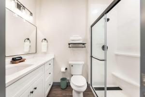 baño blanco con aseo y ducha acristalada en Bold and Bright Stay with Cher & Etta James Flair, en Macon 25 fotos más