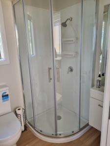 a shower stall in a bathroom with a toilet at Tiny House 2 by the beach in Greymouth