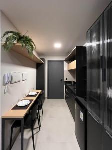 a kitchen with a table and some black cabinets at Flat aconchegante à 300m do mar! in Cabedelo