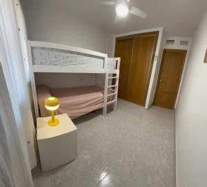 a small bedroom with a bunk bed and a table at Apartamento Isla Plana in El Mojón +20 photos