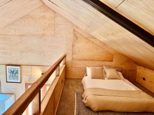 a bed in the attic of a house at Charming Studio in Somersby in Somersby