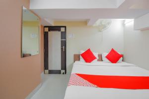 Calcutta Bara BazarにあるHotel O Lindsay Inn Guest Houseの赤い枕が付いたベッド2台が備わる客室です。 +21枚の写真