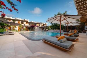una piscina con tumbonas y sombrillas junto a un hotel en Hotel Fiesta, en Puerto Ayora