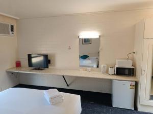 LeongathaLeongatha Motel的客房设有书桌、电视和微波炉。