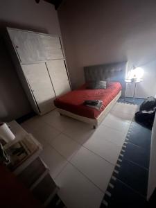 a bedroom with a bed and a table with a lamp at QUINTA LA ARAUCARIA -Paraná in Paraná