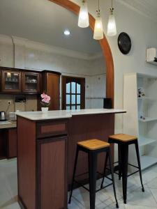 a kitchen with a counter and two stools at Spacious Bungalow with Large Outdoor in Sabah in Penampang