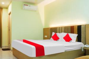 a bedroom with a bed with red and white pillows at Collection O Sri Subhamastu Grand in Vijayawada
