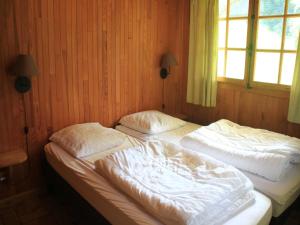 two twin beds in a room with a window at Chalet in Vonnes near Chairlifts & Shuttle in Châtel