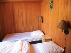 two beds in a room with wood paneled walls at Chalet in Vonnes near Chairlifts & Shuttle in Châtel +8 photos