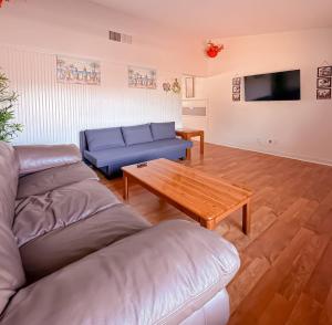 een woonkamer met een blauwe bank en een tafel bij Vacationhome - Privatepool Gardenyard in Las Vegas