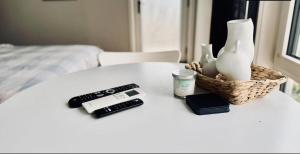 a table with a remote control a cell phone and a remote at Cozy & Lux 1 Bed Studio Retreat in Weston Creek