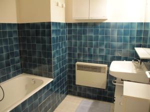 a blue tiled bathroom with a sink and a bath tub at Apartment for 4 people in Chatel in Châtel