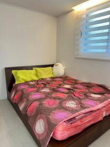 a bedroom with a large bed with a flowery blanket at Shiaring in Seoul +12 photos
