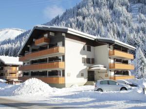 沙泰勒Studio in Châtel near Portes du Soleil Ski Area的雪地中的一座建筑,前面有停车位 更多23张照片