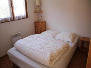 an unmade bed in a bedroom with a window at Jonquilles apartment for 4 people in Châtel