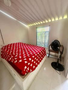 a bedroom with a bed with a red blanket with white hearts at Casa de campo rural con piscina fenomenal in El Guabinal