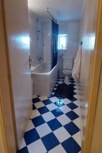baño con suelo de color azul y blanco a cuadros en Seaside holiday house Sibenik - 23990, en Šibenik 14 fotos más
