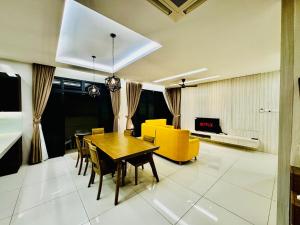 - un salon avec une table à manger et des chaises jaunes dans l'établissement Opulent Villa for 20pax BBQ, Steps to Beach Market, à Batu Ferringhi