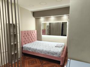 a bedroom with a pink bed and a mirror at Mini Suite JyC in Manta