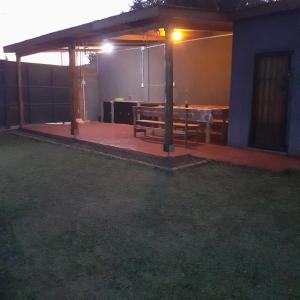 a patio with a wooden table and a bench at Cabañas Juca in Puerto Iguazú
