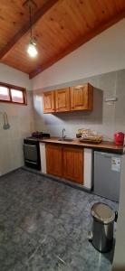 a kitchen with wooden cabinets and a stove top oven at Cabañas Juca in Puerto Iguazú