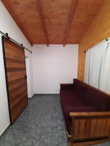 a living room with a couch and a door at Cabañas Juca in Puerto Iguazú
