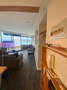 a living room with a couch and chairs and a television at San Alfonso del mar ,gran vista in Algarrobo