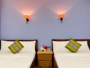カンポットにあるKampot Orkide Guesthouseのランプ2つが付いた部屋のベッド2台 +6枚の写真