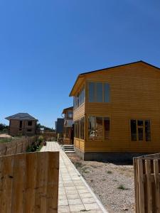 a wooden house with a fence in front of it at WooD_House_Issyk-Kul in Bosteri