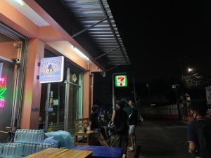 a group of people standing outside of a store at night at Stay Strays Hostel in Bangkok