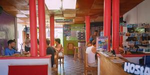 a group of people sitting at a table in a restaurant at Deakachimba Hostel in Granada