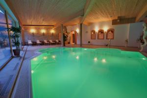 einem großen Pool in einem Gebäude mit einer Decke in der Unterkunft Hotel Bellaval Scuol in Scuol