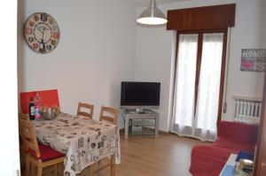 a living room with a table and a television at Betty's House in Mandello del Lario