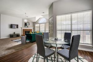 a living room with a glass table and chairs at Gorgeous cozy home in nature serene neighborhood! in DeSoto