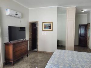 a bedroom with a bed and a tv and a dresser at Casa Condomínio Luxo Cop 30 in Ananindeua