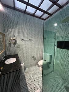 a bathroom with a glass shower and a toilet at Casa Condomínio Luxo Cop 30 in Ananindeua