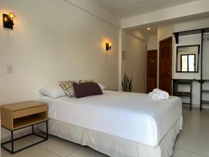 a bedroom with a large white bed in a room at Calma Chicha Rooms in Playa del Carmen