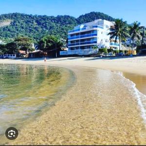 a view of a beach with a building in the background at Casa em Condomínio em Mangaratiba in Mangaratiba